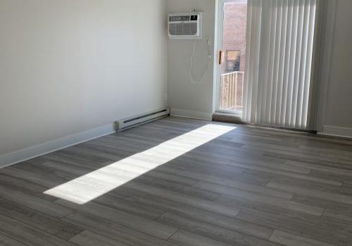 An 空调 unit sits on a wooden floor in a room with white walls and wood floors